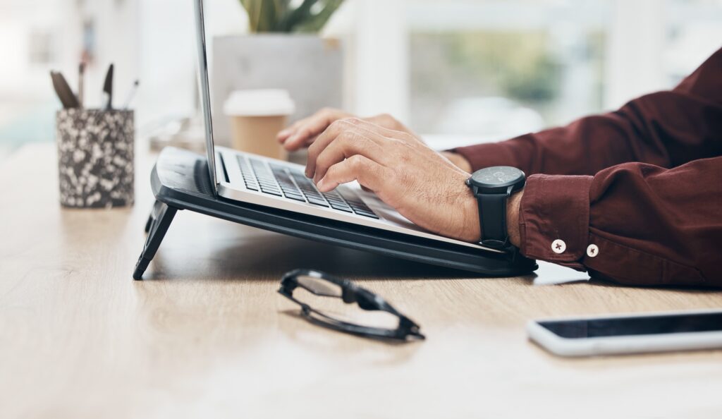 Professional working on a laptop at a modern desk, symbolizing remote productivity and the flexibility of tailored technical staffing solutions.