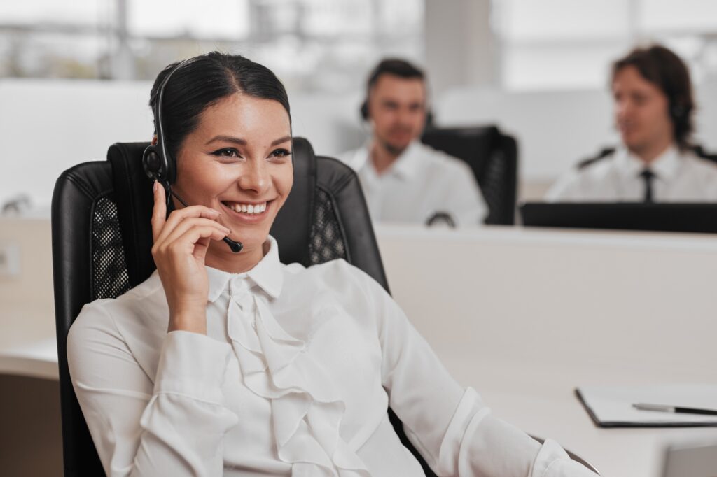 Smiling recruiter wearing a headset in a modern office call center — recruitment agency contact support team assisting clients and candidates professionally.