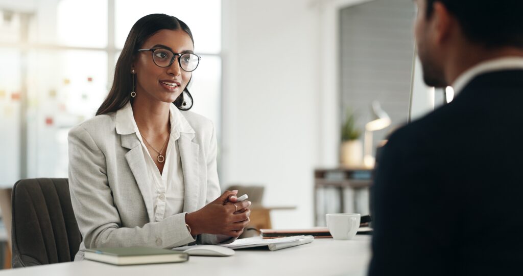 Confident recruiter speaking with a candidate in a modern office environment, representing professional contract staffing services tailored to business needs.
