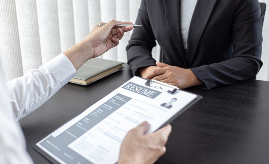 Staffing agency near me conducting a professional job interview, with a recruiter discussing a candidate’s resume in a modern office setting.
