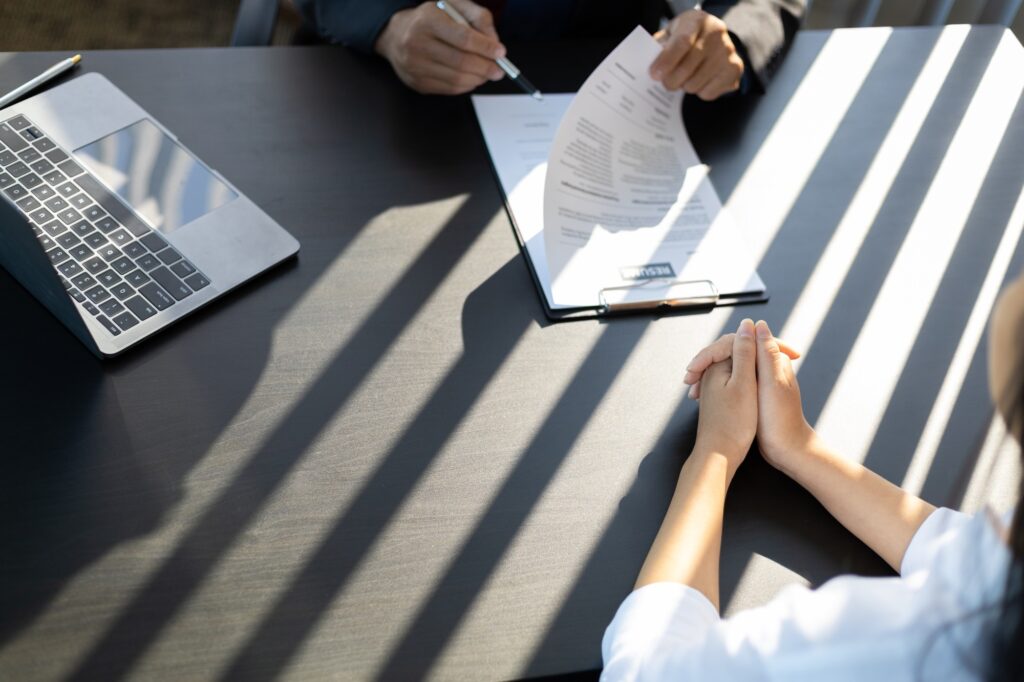 Job candidate and recruiter in a professional interview setting, reviewing a resume and discussing opportunities to find the best job for my skills. 