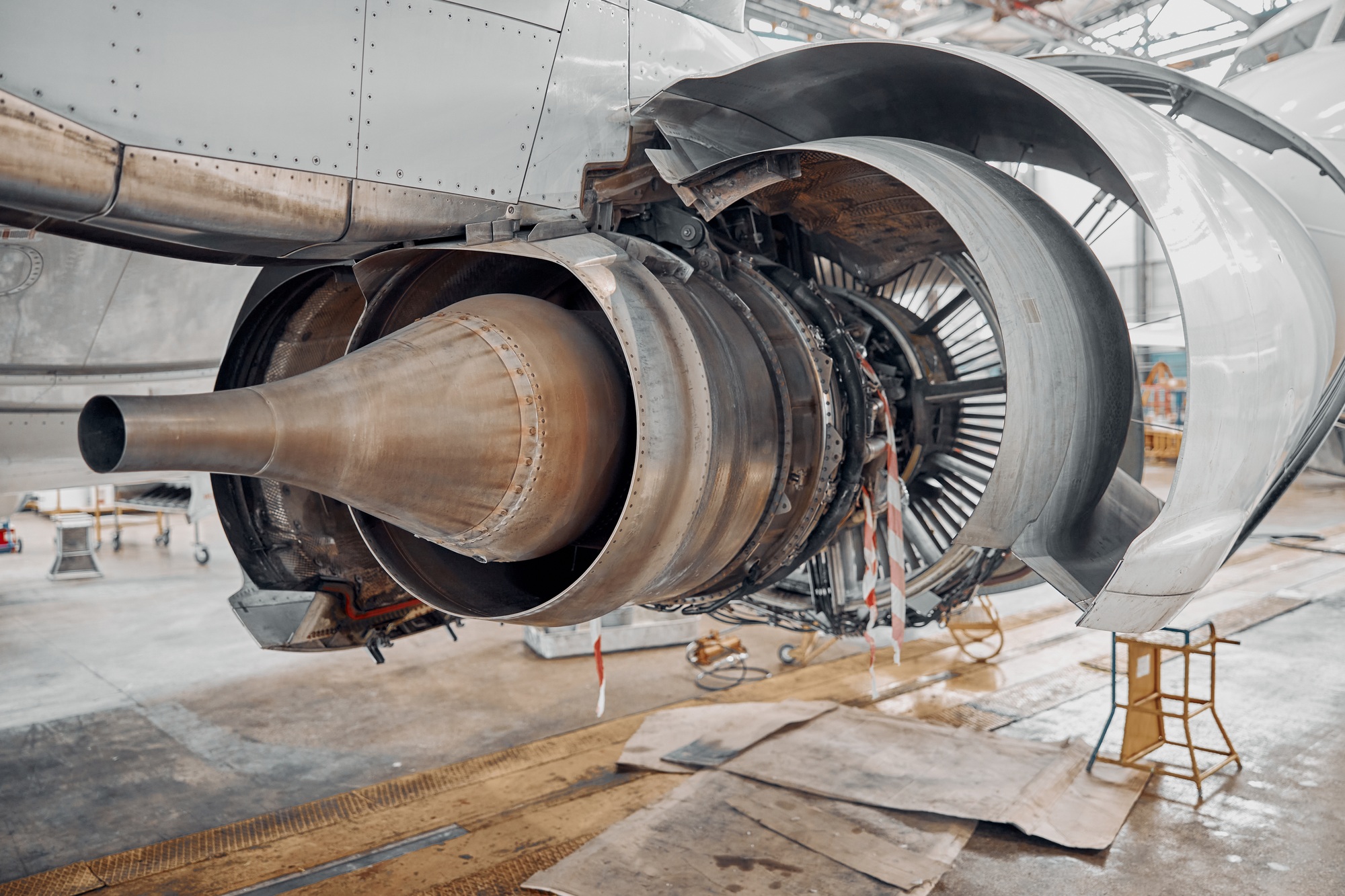 Exposed aircraft engine under inspection in a maintenance hangar, highlighting the precision and expertise of aerospace engineers in action.
