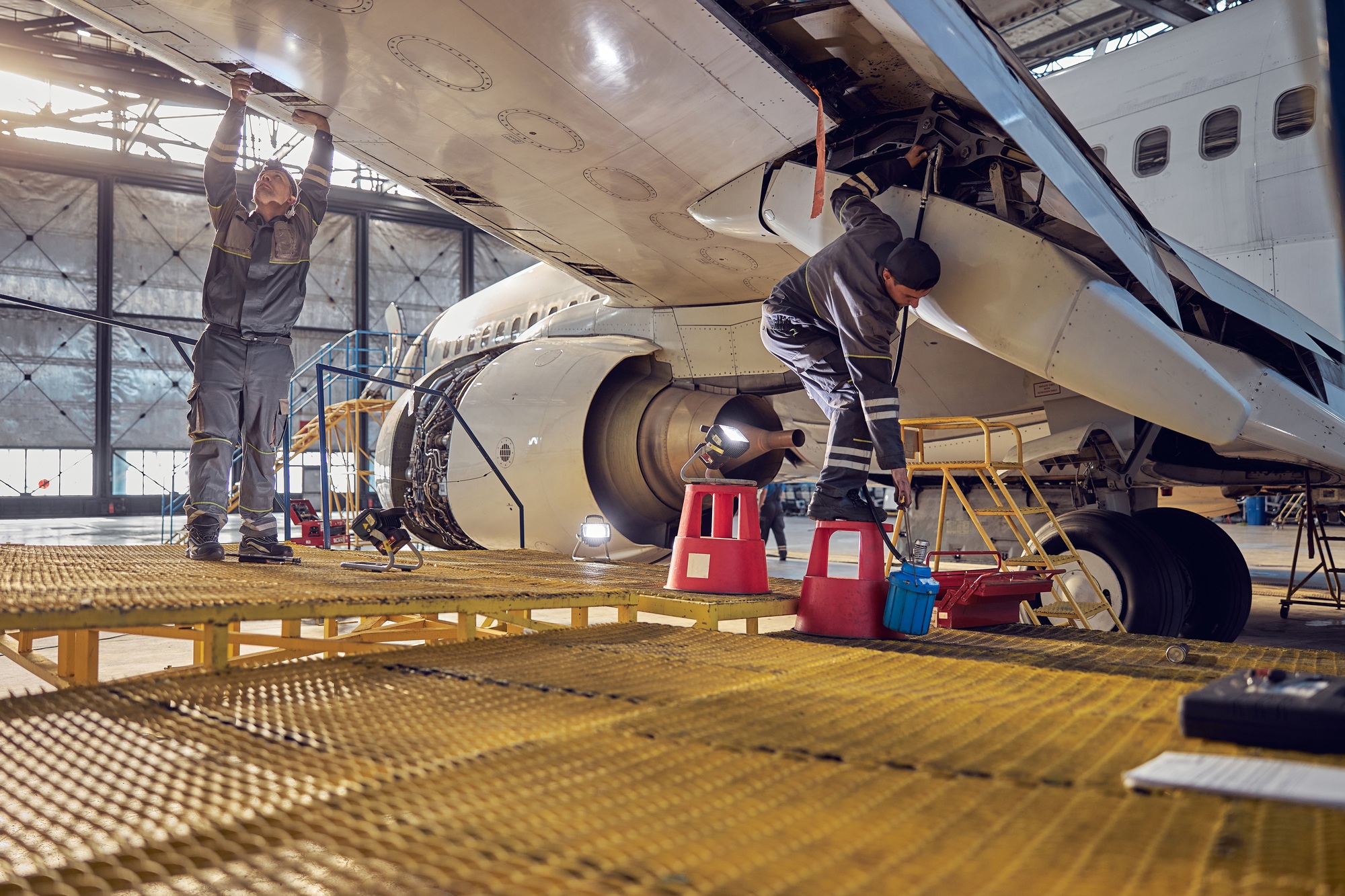 Technicians performing aircraft maintenance inside a hangar, illustrating the hands-on talent supplied by top aerospace staffing companies.