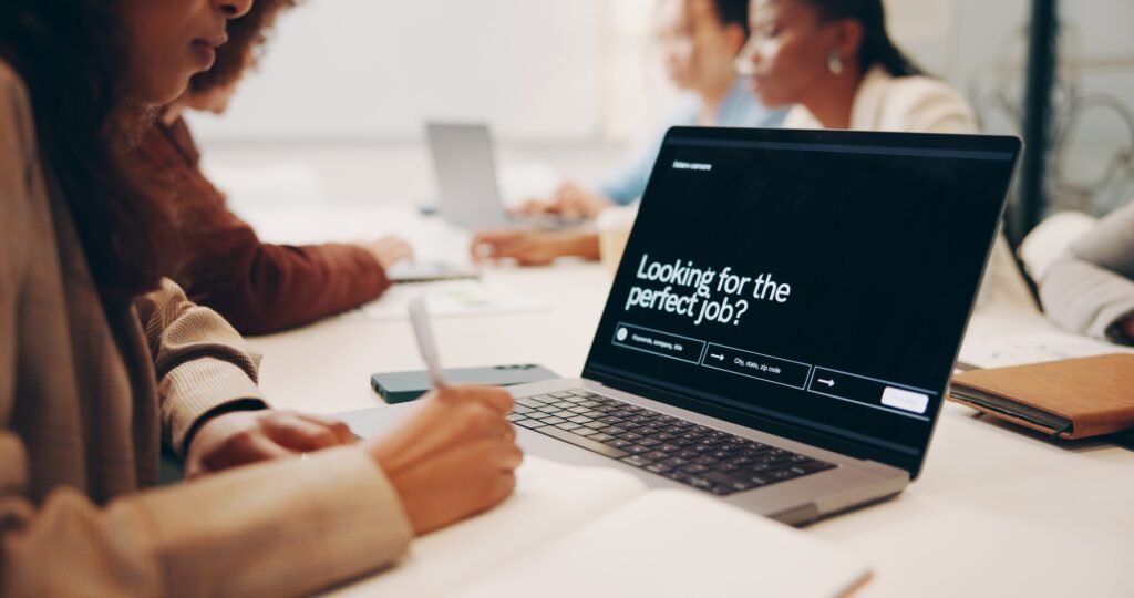 Job seekers engaged in a modern workspace with a laptop displaying a job search interface—illustrating the power of tailored, industry-specific recruitment.
