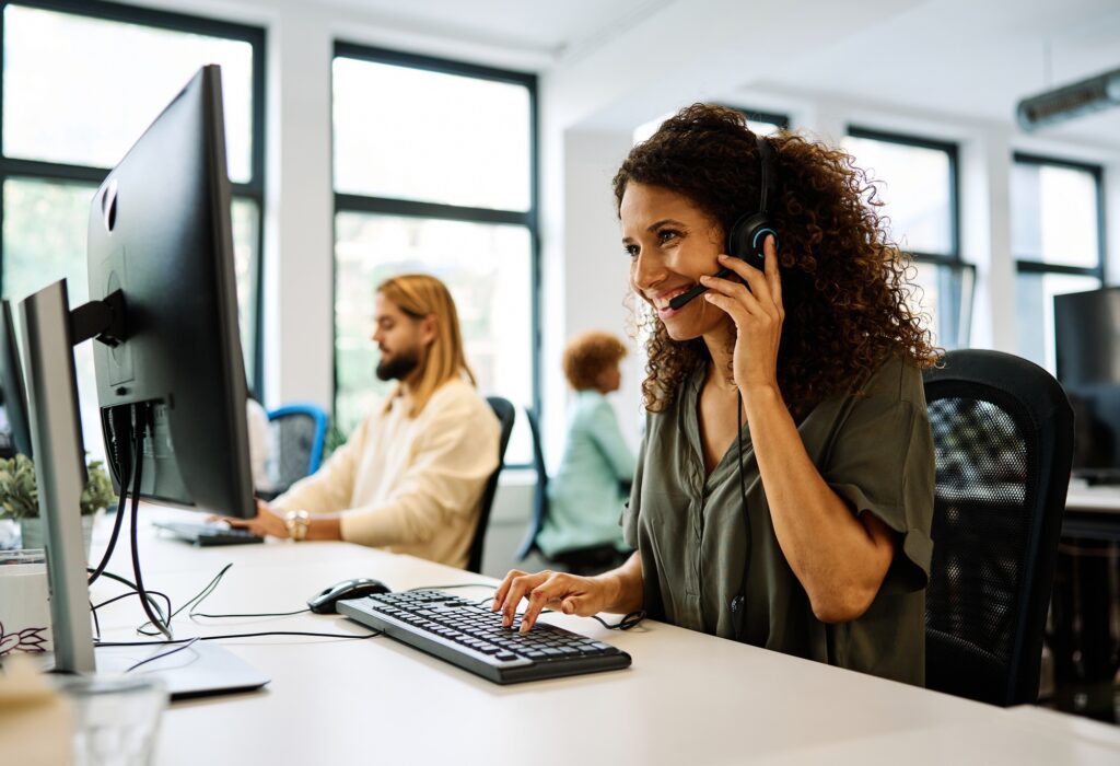 Focused professional typing at a workstation with a headset on—showcasing the accuracy and efficiency delivered through expert data entry staffing services.

